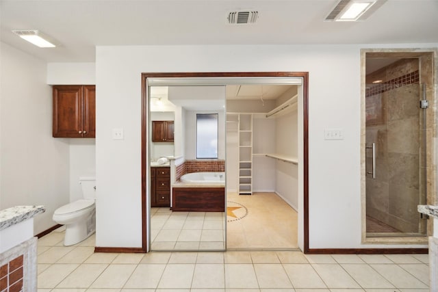 full bathroom featuring toilet, tile patterned flooring, vanity, and shower with separate bathtub