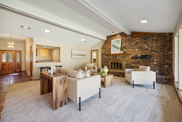 living room featuring a brick fireplace, vaulted ceiling with beams, brick wall, a notable chandelier, and light carpet