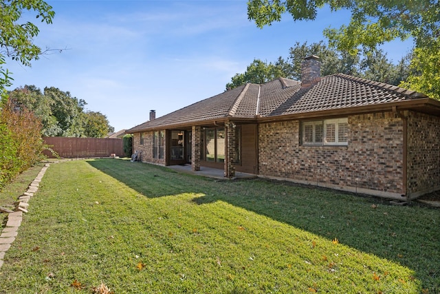 rear view of property featuring a yard