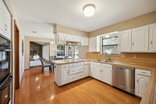 kitchen featuring black appliances, sink, kitchen peninsula, light hardwood / wood-style flooring, and white cabinetry