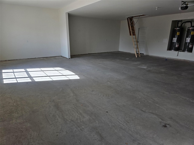 unfurnished room featuring electric water heater and concrete floors