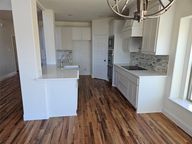 kitchen with dark wood-type flooring, sink, black appliances, white cabinets, and backsplash