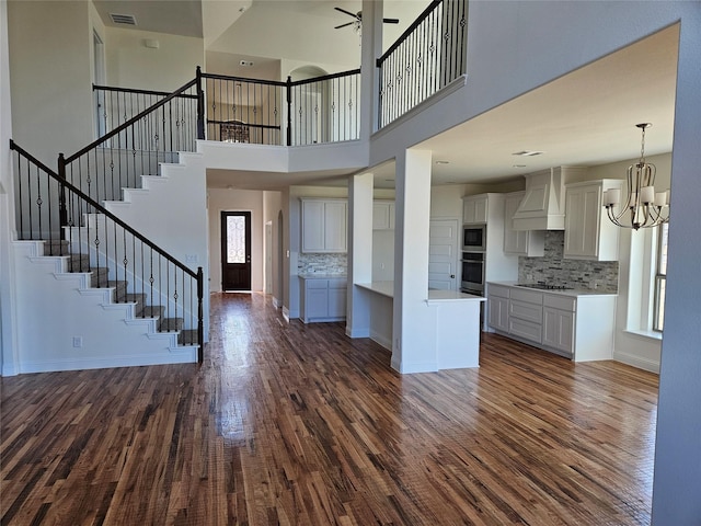 kitchen with tasteful backsplash, a healthy amount of sunlight, custom range hood, and stainless steel oven