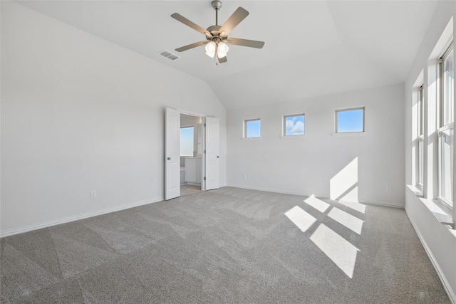 interior space with visible vents, baseboards, a ceiling fan, light colored carpet, and lofted ceiling