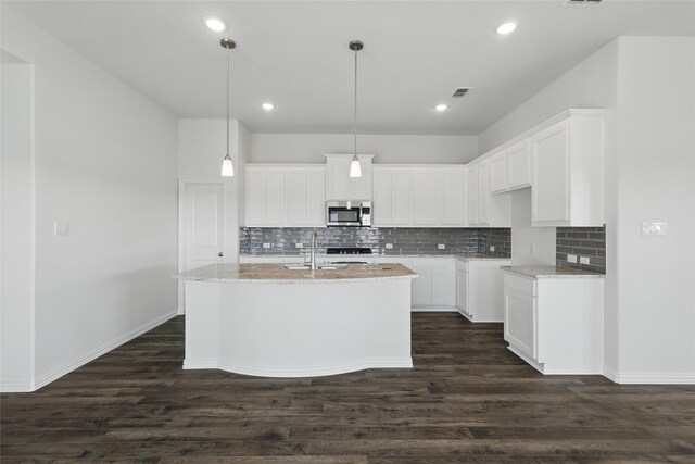 kitchen with a kitchen island with sink, sink, light wood-type flooring, appliances with stainless steel finishes, and light stone counters