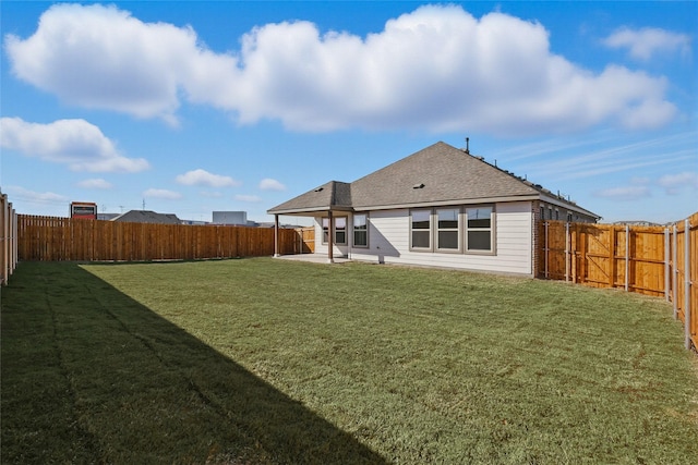 back of house featuring a patio area, a fenced backyard, a shingled roof, and a lawn