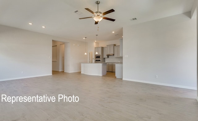 unfurnished living room featuring ceiling fan and light hardwood / wood-style floors