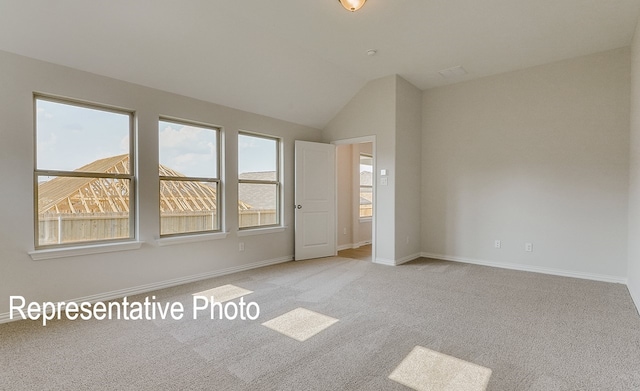 carpeted spare room with lofted ceiling