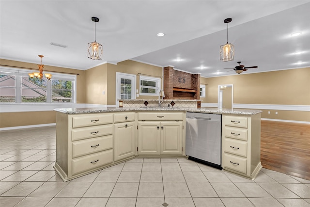 kitchen featuring stainless steel dishwasher, light stone counters, and cream cabinets