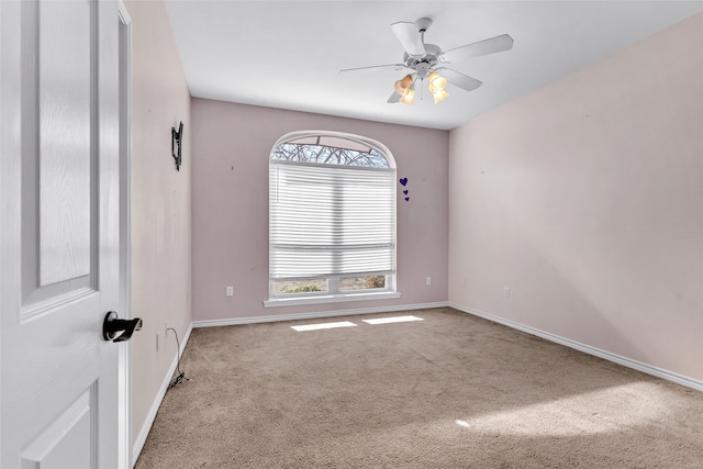 carpeted spare room with ceiling fan and plenty of natural light