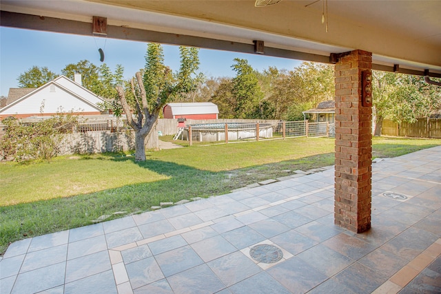 view of patio with ceiling fan and a pool