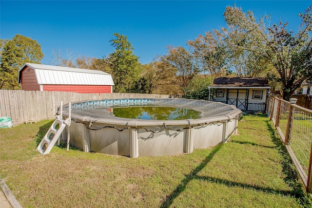 view of swimming pool featuring a lawn and a storage unit