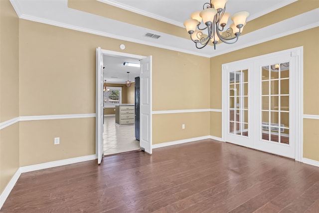 unfurnished room featuring hardwood / wood-style flooring, a notable chandelier, and ornamental molding