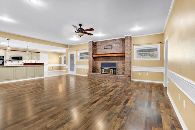 unfurnished living room featuring ceiling fan, dark hardwood / wood-style flooring, and crown molding