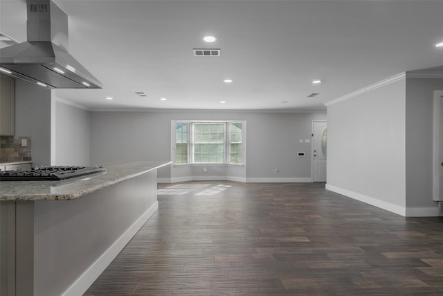 kitchen featuring light stone counters, wall chimney exhaust hood, stainless steel gas cooktop, dark wood-type flooring, and crown molding