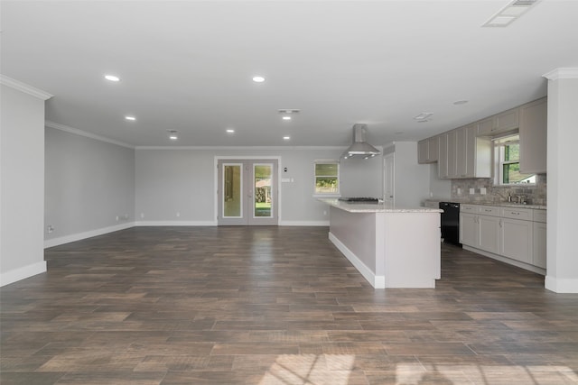 kitchen with plenty of natural light, dark wood-type flooring, and wall chimney range hood