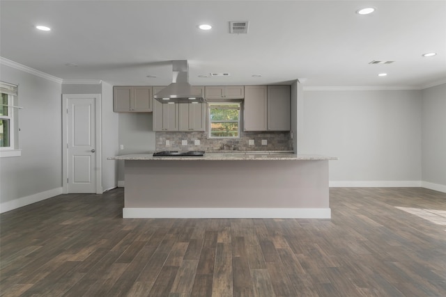 kitchen featuring gray cabinetry, light stone counters, dark hardwood / wood-style flooring, and wall chimney range hood