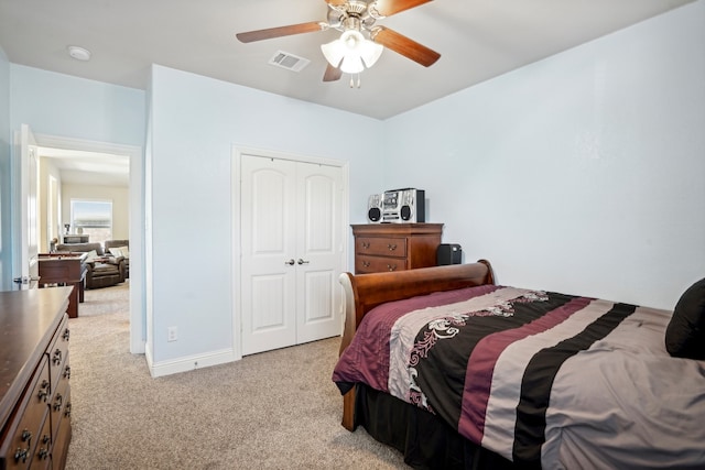 bedroom featuring ceiling fan, light colored carpet, and a closet