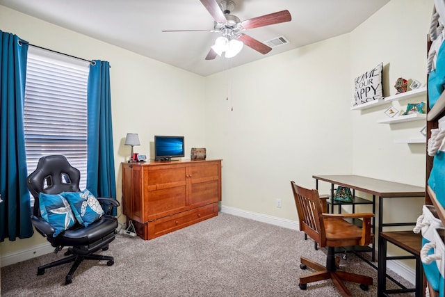 carpeted home office featuring ceiling fan