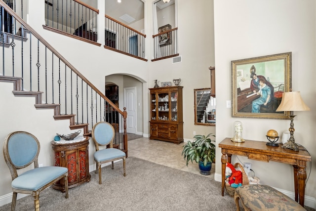 carpeted foyer featuring a high ceiling