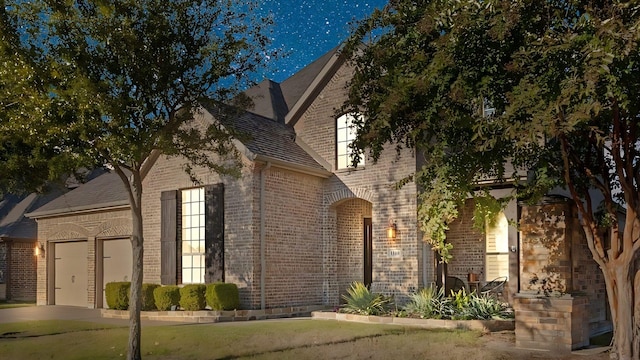 view of side of property with a garage and a lawn