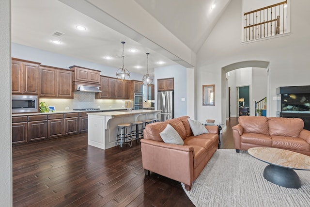 1100 Wedgewood Dr, Forney, TX 75126 - living room featuring dark wood-style floors, arched walkways, recessed lighting, and high vaulted ceiling