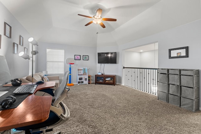 office space with a tray ceiling, carpet, and a ceiling fan