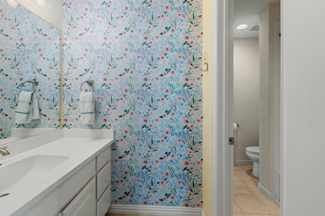 bathroom featuring vanity, tile patterned flooring, toilet, and baseboards