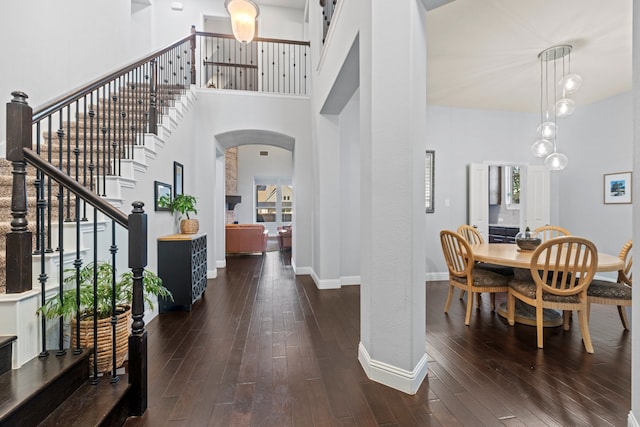 1100 Wedgewood Dr, Forney, TX 75126 - foyer with arched walkways, baseboards, dark wood-type flooring, a high ceiling, and stairway
