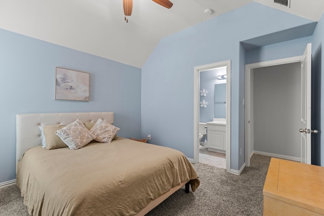 bedroom with carpet floors, vaulted ceiling, baseboards, and ensuite bathroom