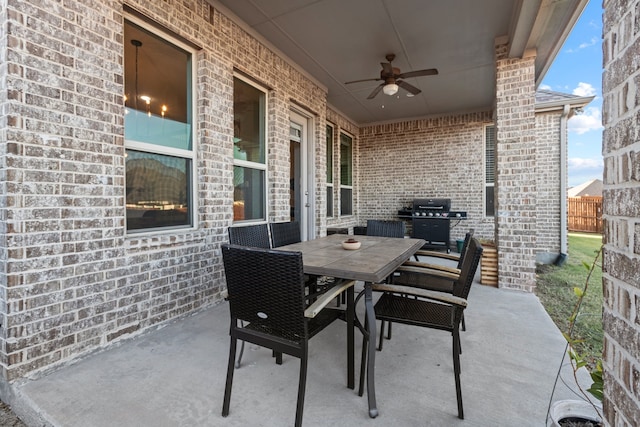 view of patio with outdoor dining space, ceiling fan, area for grilling, and fence