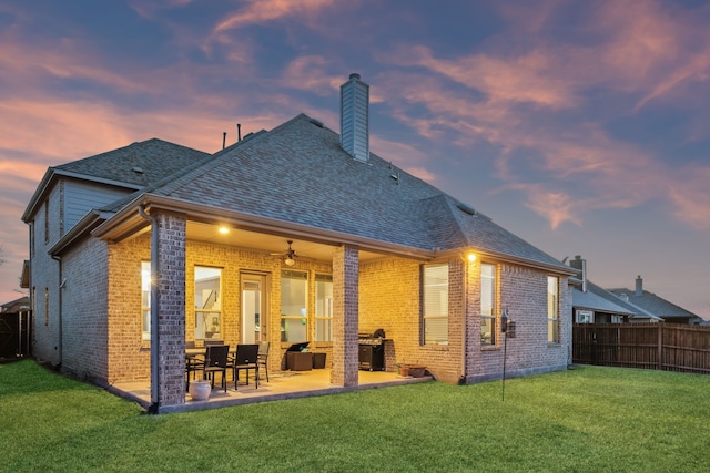 1100 Wedgewood Dr, Forney, TX 75126 - back of house at dusk featuring brick siding, a chimney, ceiling fan, and a patio area