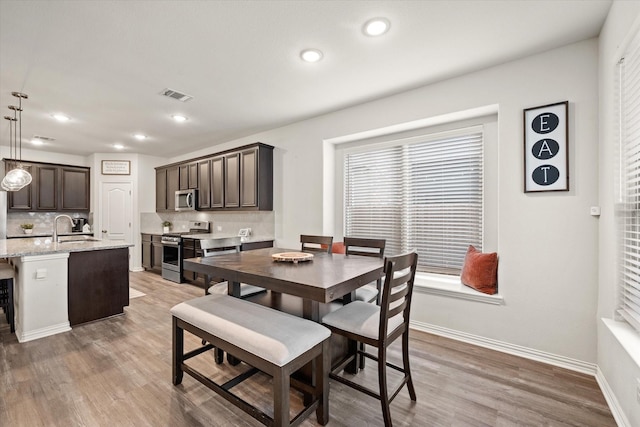 dining space featuring hardwood / wood-style flooring and sink