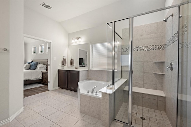 bathroom with tile patterned floors, separate shower and tub, lofted ceiling, and vanity