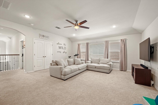 living room featuring vaulted ceiling, ceiling fan, and light colored carpet