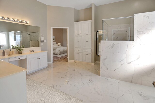 bathroom with a marble finish shower, marble finish floor, vanity, and ensuite bath