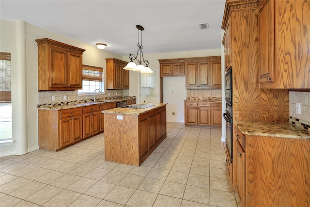 kitchen with light stone counters, brown cabinets, decorative light fixtures, a center island, and light tile patterned flooring