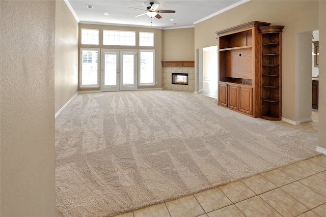 unfurnished living room featuring a tile fireplace, ornamental molding, and light carpet