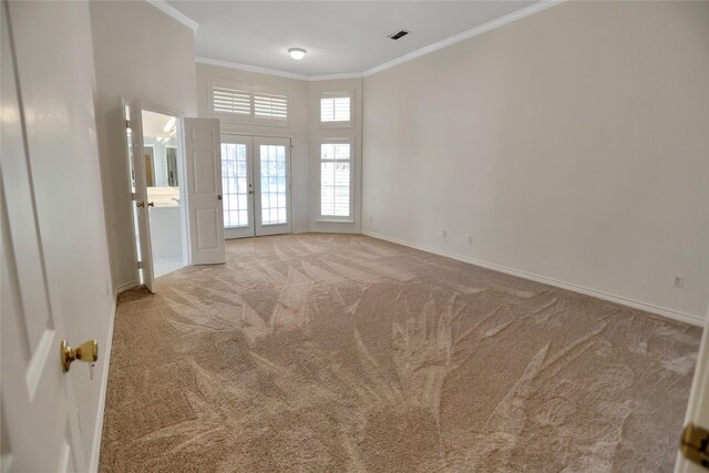 carpeted empty room with french doors and ornamental molding