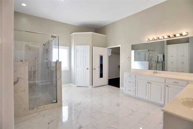 bathroom with marble finish floor, a marble finish shower, two vanities, a sink, and baseboards