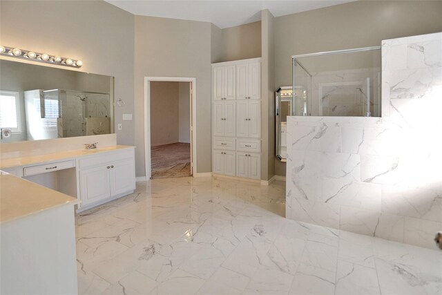 bathroom with marble finish floor, a marble finish shower, and vanity