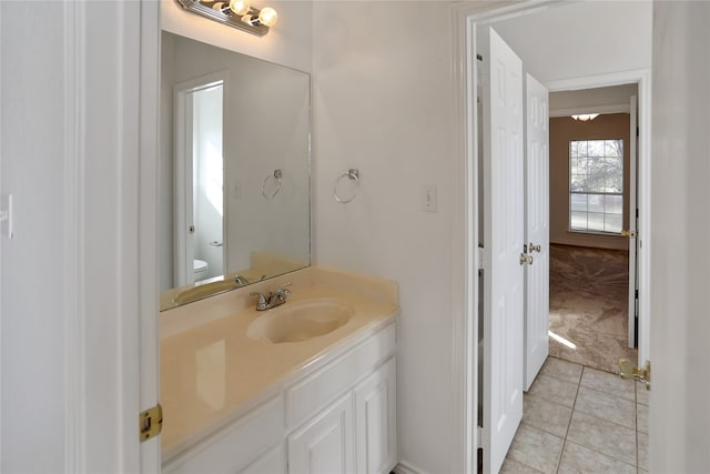 half bathroom with vanity, toilet, and tile patterned floors