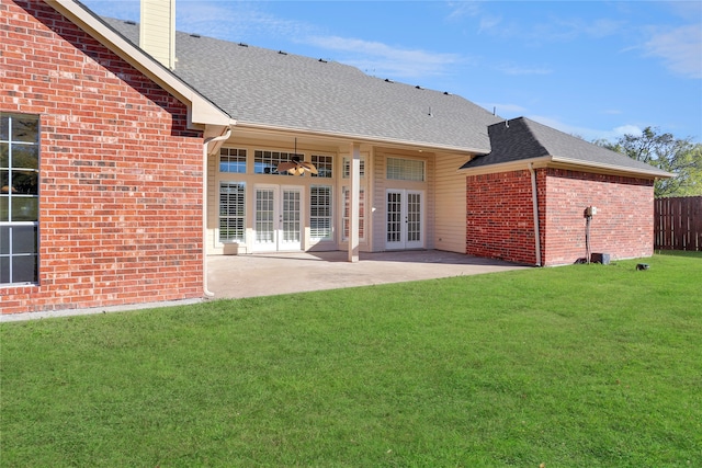 rear view of house featuring french doors, a patio, and a lawn