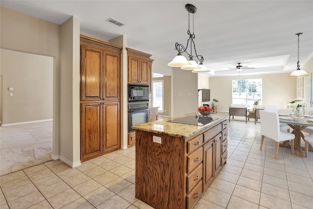 kitchen featuring pendant lighting, black appliances, light tile patterned floors, and a center island