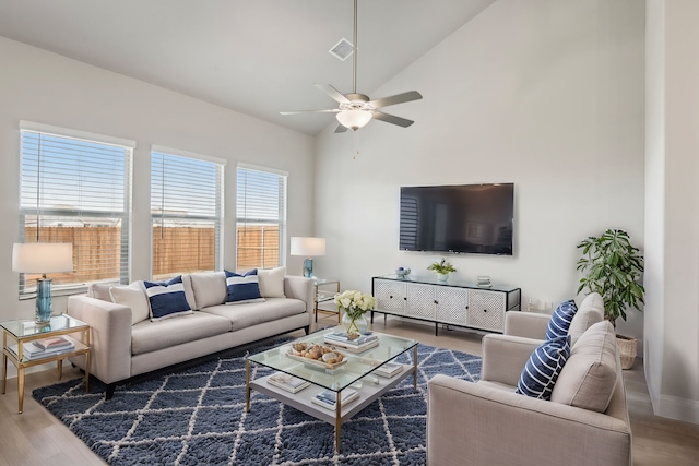 living room featuring ceiling fan, high vaulted ceiling, and wood-type flooring