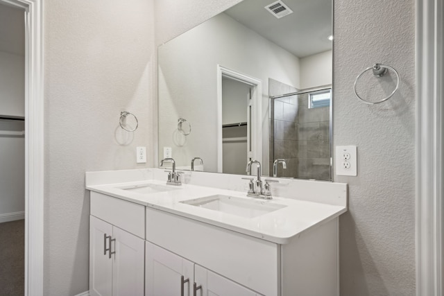 bathroom featuring vanity and a shower with door