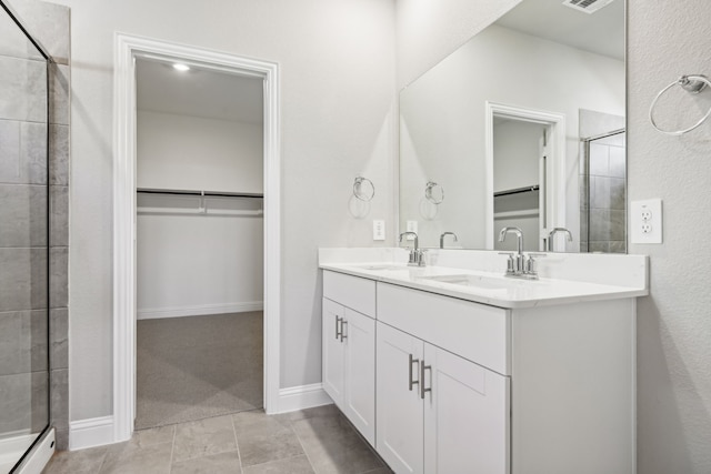 bathroom with tile patterned flooring, vanity, and a shower with shower door