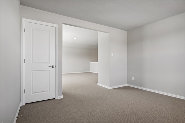 spare room with dark carpet