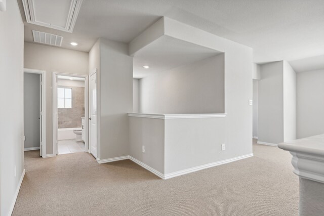 corridor featuring light colored carpet