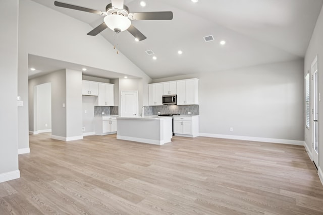 kitchen with white cabinets, a center island with sink, high vaulted ceiling, and light hardwood / wood-style flooring